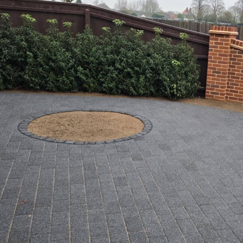 Charcoal block paving with circular planting bed