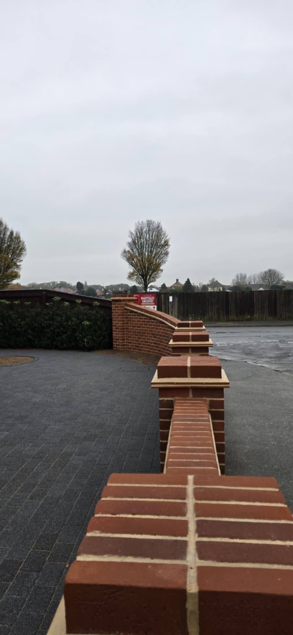 Curved facing brick wall with brick on edge coping, Martello Ground